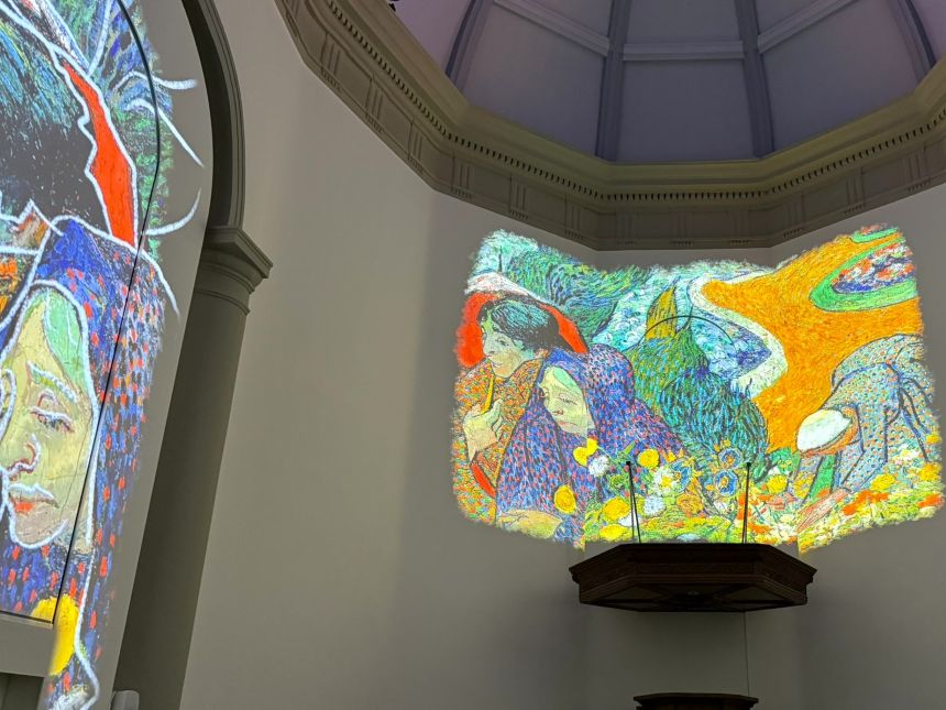 Projectie in een kerk van twee vrouwen in fleurige kleding