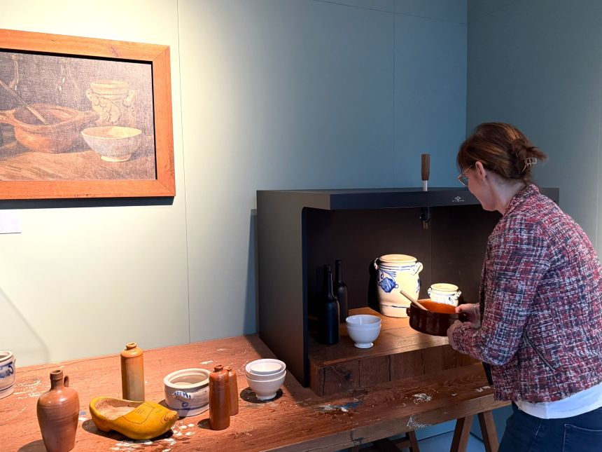 Vrouw zet een stilleven klaar dat ze ziet op een schilderij van Van Gogh
