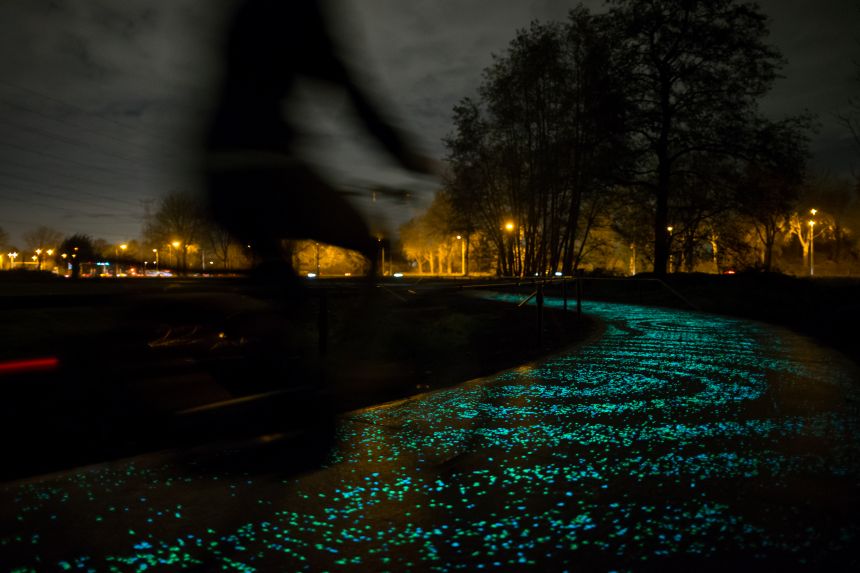 oplichtend fietspad in het donker met een fietser
